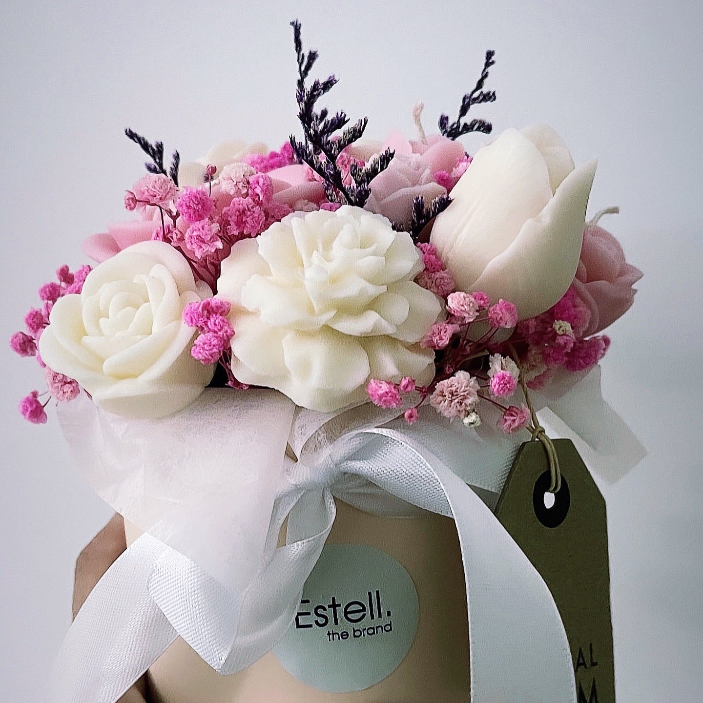 Bouquet of flowers in a box with 'Estell' branding on a light gray background