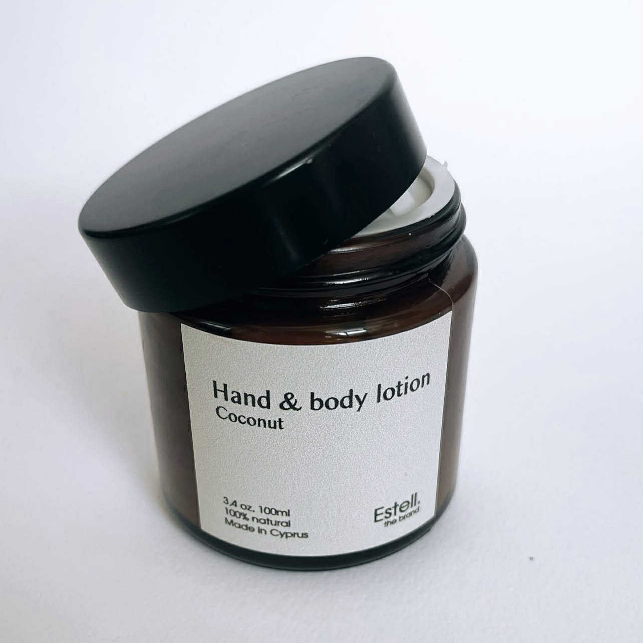Jar of hand and body lotion labeled 'Coconut' by Estelle & Thales on a white background
