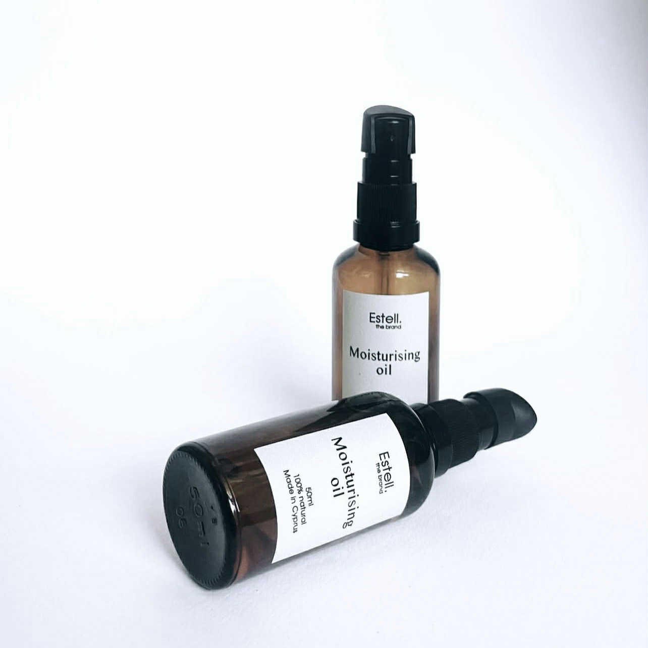Two bottles of Estelle & Thalia moisturizing oil on a white background