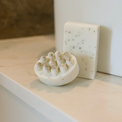 Two soap bars on a bathroom counter with a mirror in the background